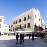 Accediamo ora all�adiacente Piazza Mercantile (ex Piazza Grande), storico cuore della vita quotidiana e amministrativa della citt� e oggi fulcro della �movida� serale giovanile. L� dove oggi dominano insegne fin troppo colarate e luci sgargianti, un tempo si teneva il mercato giornaliero